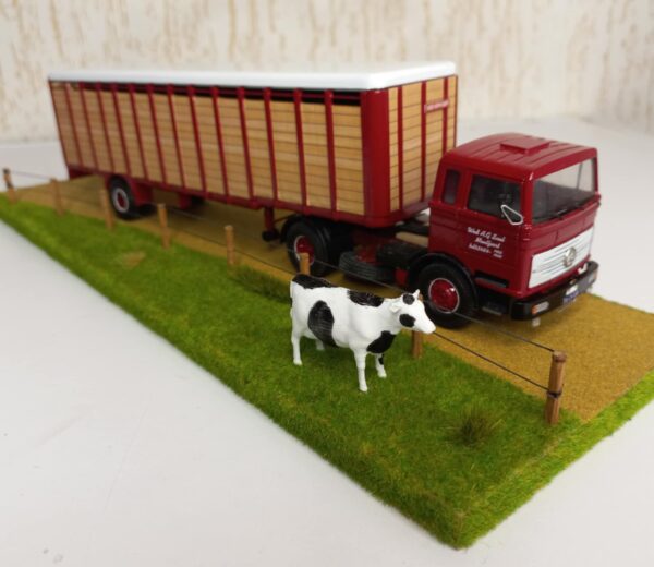 3D-geprinte veetrailer op schaal 1:50, 1:87, en 1:24, gezien vanaf de zijkant. Het model toont gedetailleerde structuren kenmerkend voor een veetrailer, inclusief ventilatieroosters. Met koe